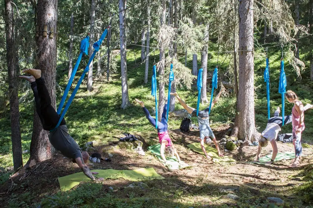 Yoga aérien en forêt, hamacs bleus suspendus aux pins